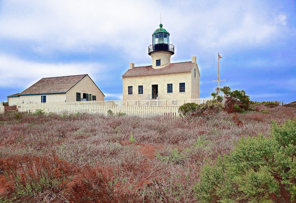 a light house sitting on top of a lush green field