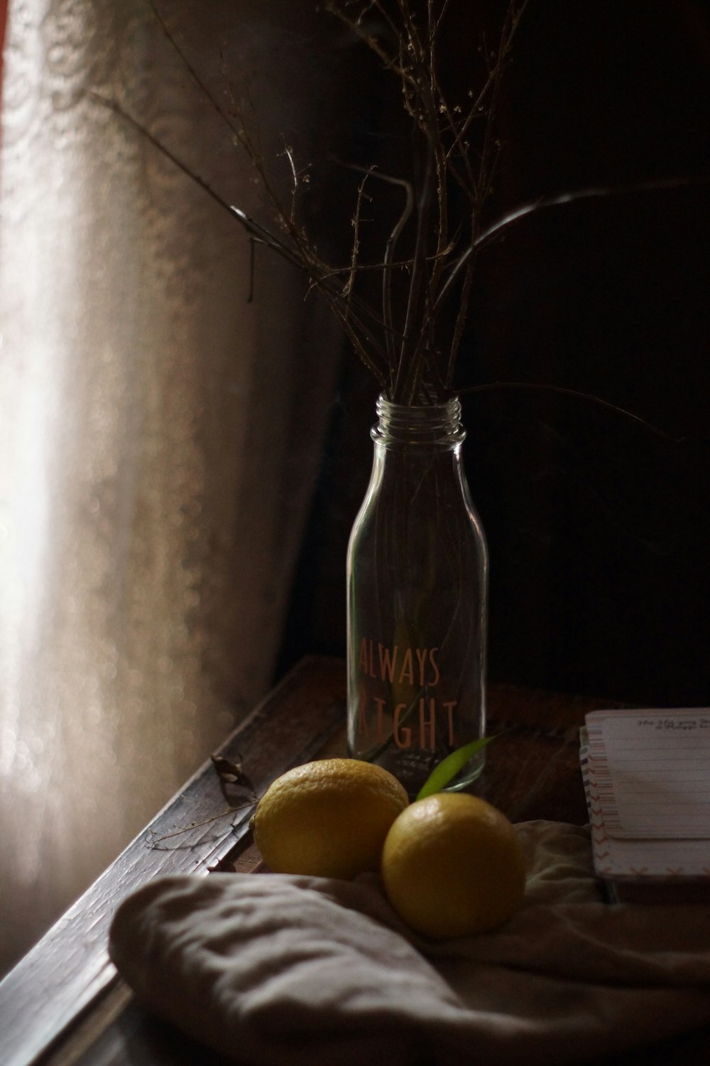 two lemons are sitting on a table next to a jar