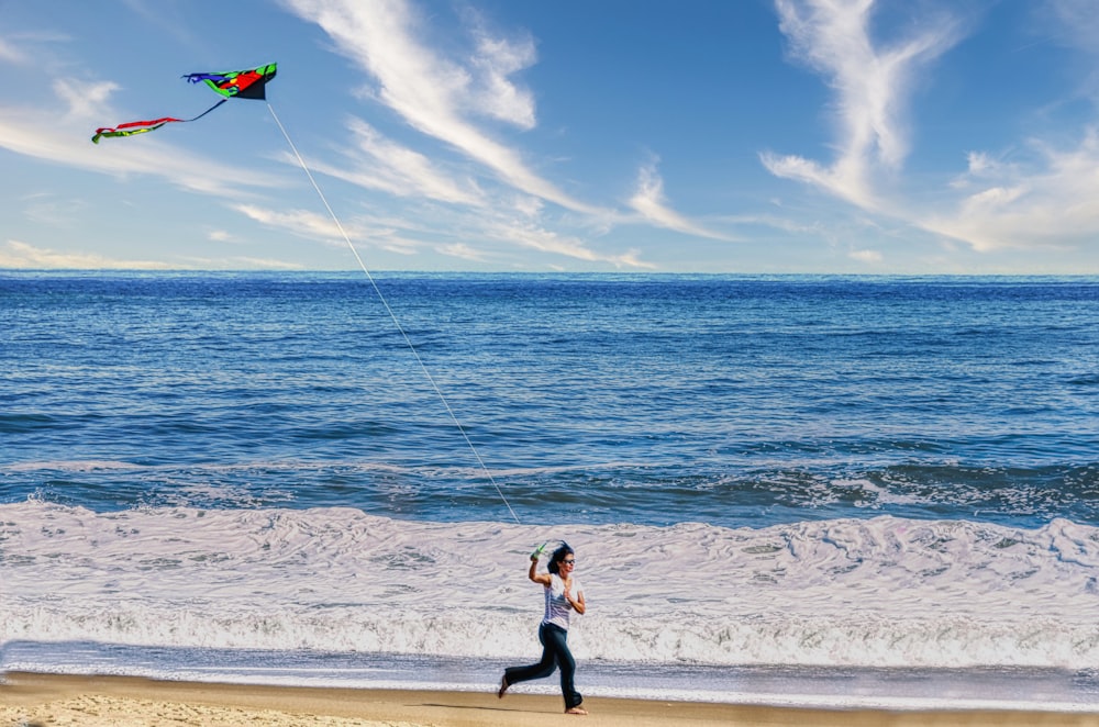 a woman is flying a kite on the beach