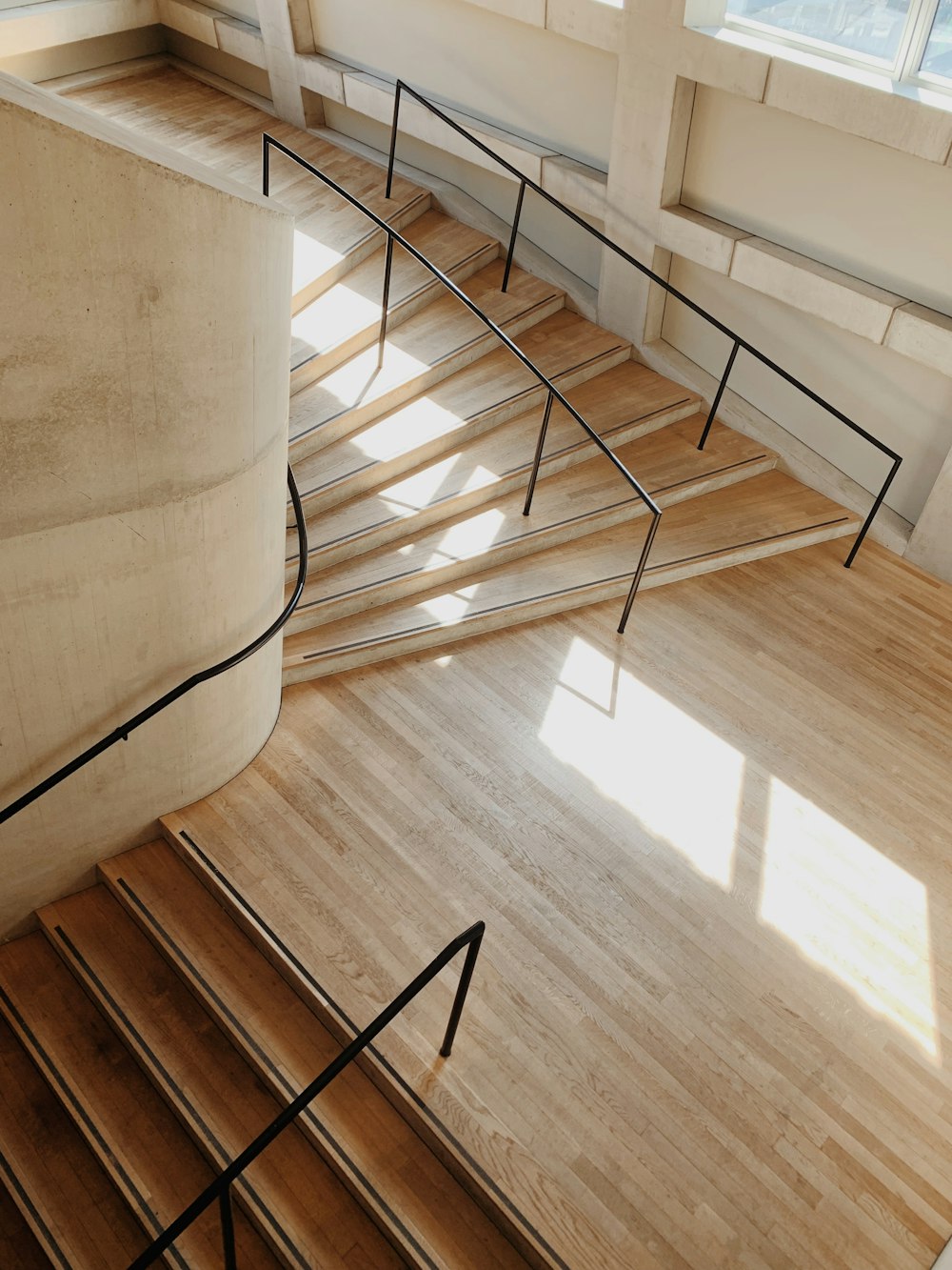 a wooden floor with metal railings and a window