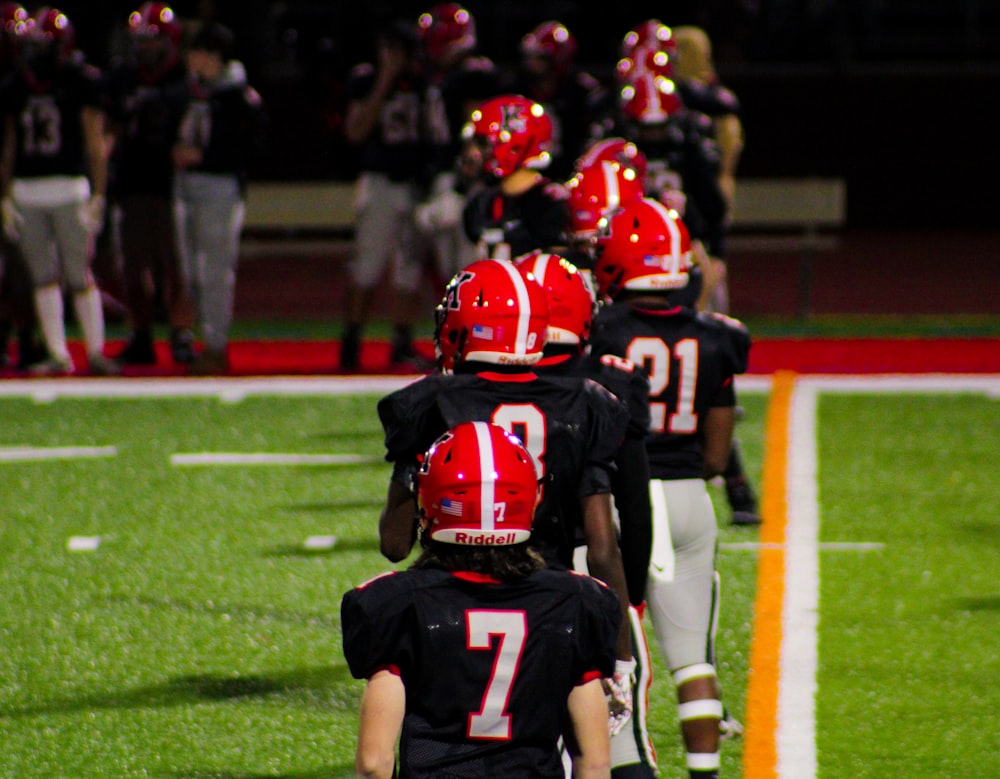 a group of young football players walking onto the field