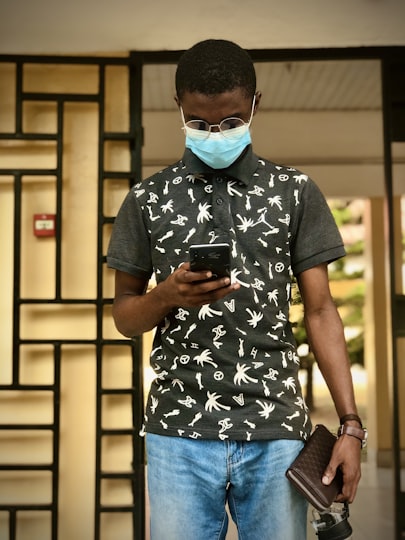 A young African man using mobile money on his phone