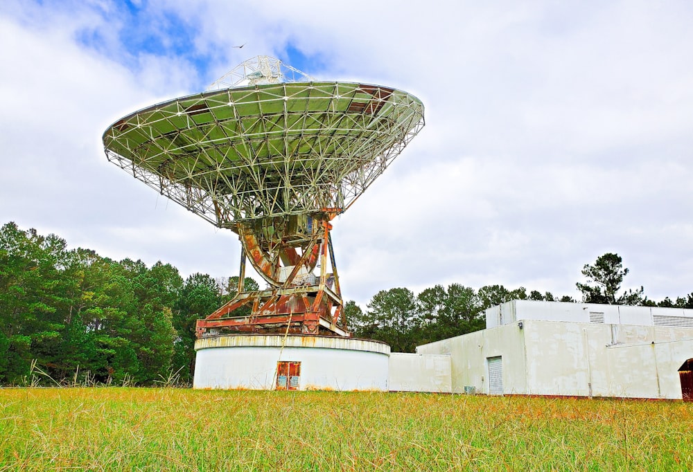 a large satellite dish sitting on top of a lush green field