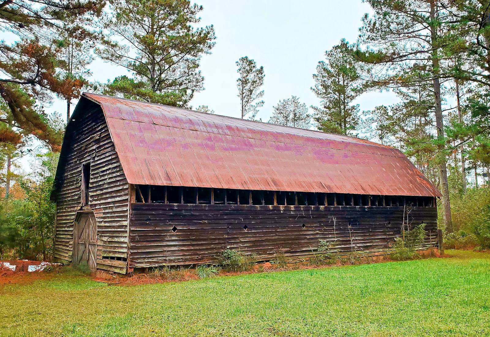 An old wooden barn with a rusted tin roof.