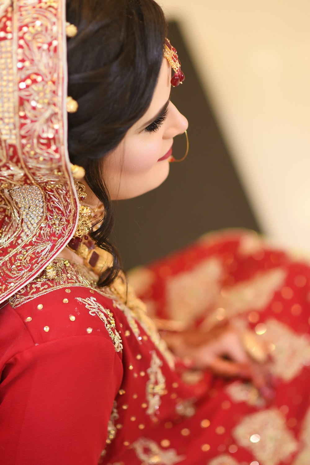 a woman in a red dress with a veil on her head