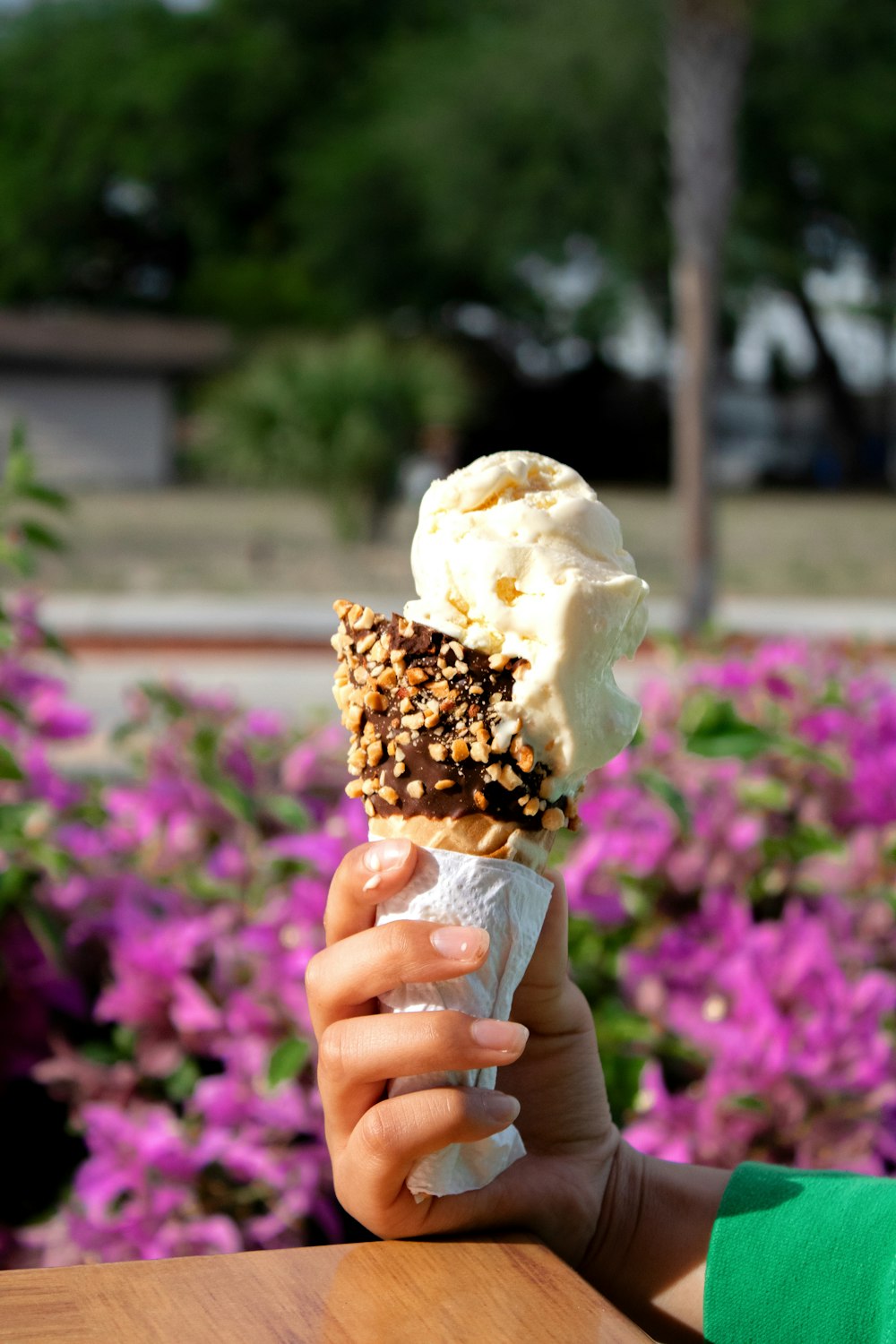 a person holding up an ice cream cone with sprinkles