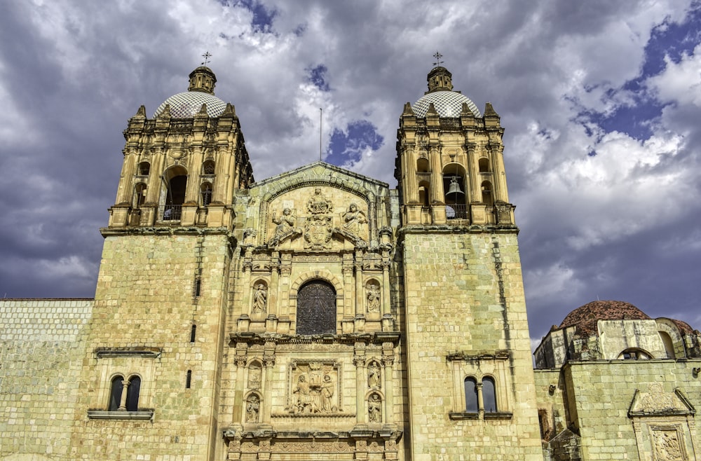 a large cathedral with two towers under a cloudy sky