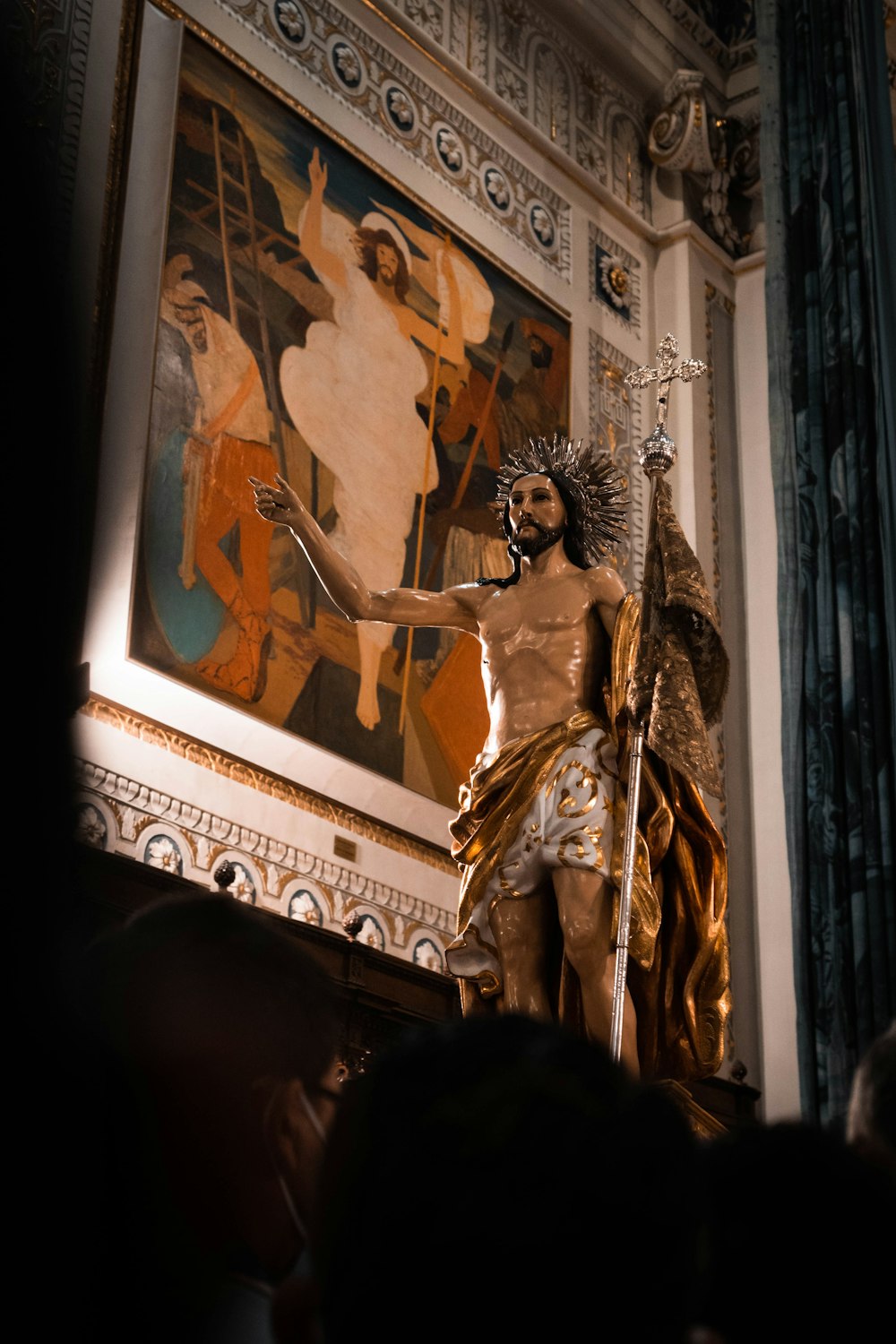 Eine Statue eines Mannes, der ein Schwert vor einem Gemälde hält