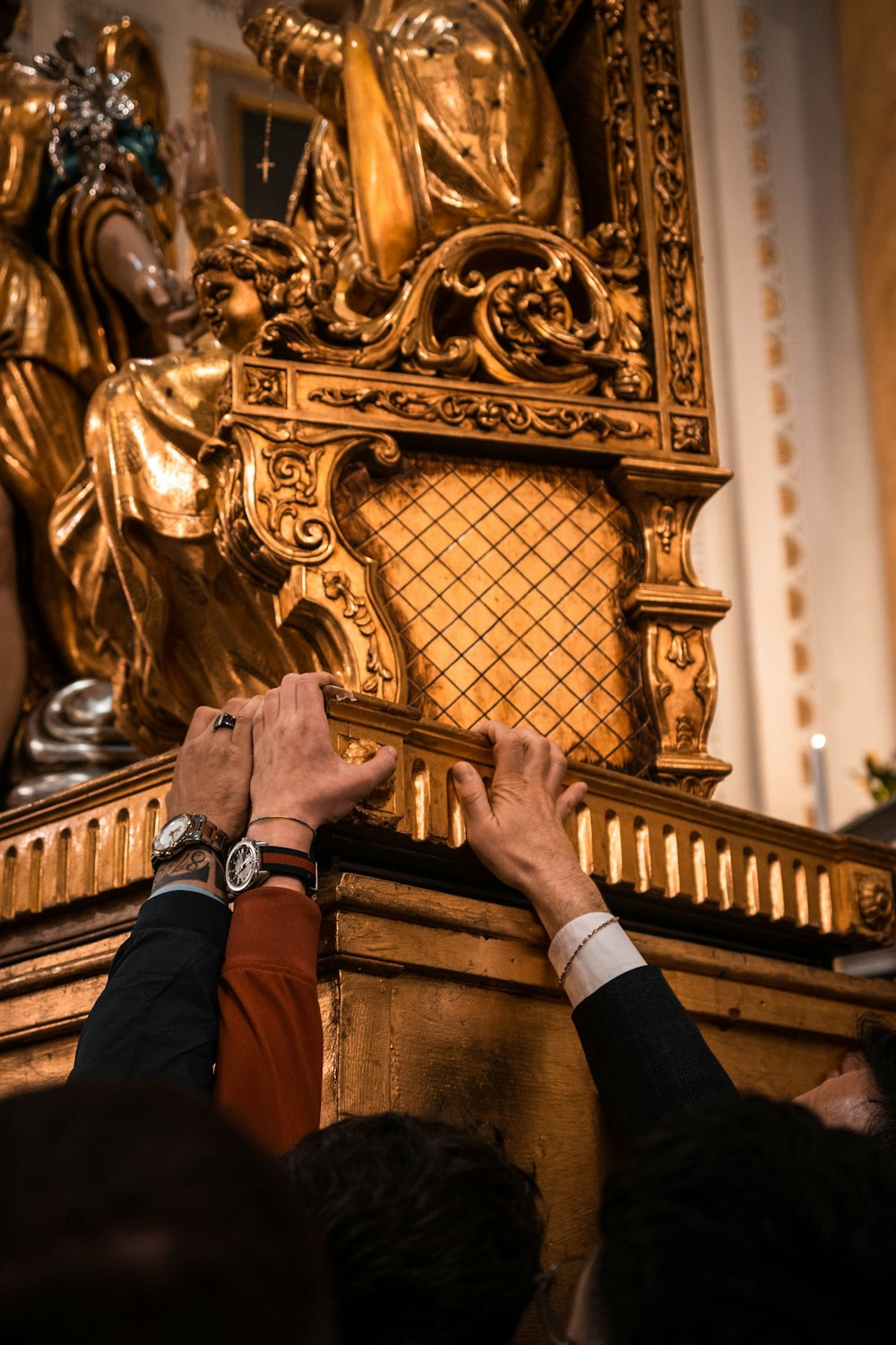 two people putting their hands on a golden statue