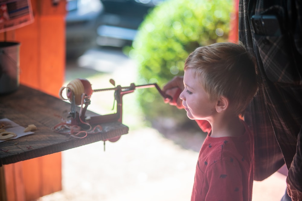 a little boy playing with a toy machine