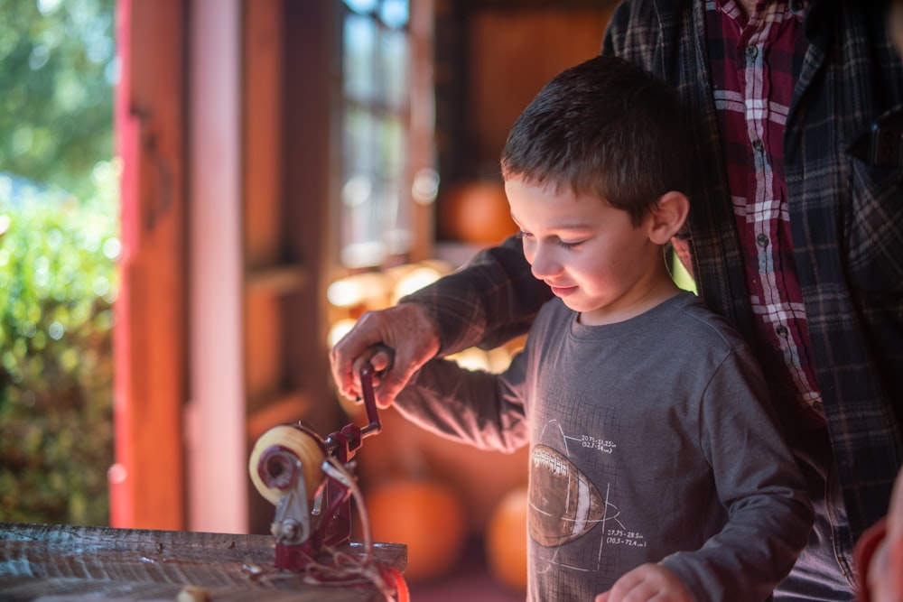 a young boy playing with a spinning wheel