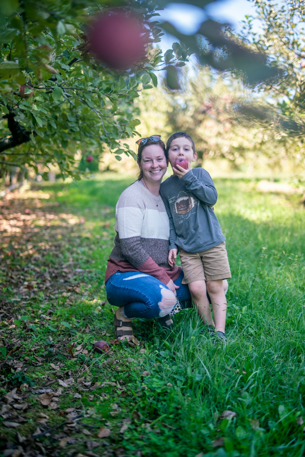 a woman and a child are sitting in the grass