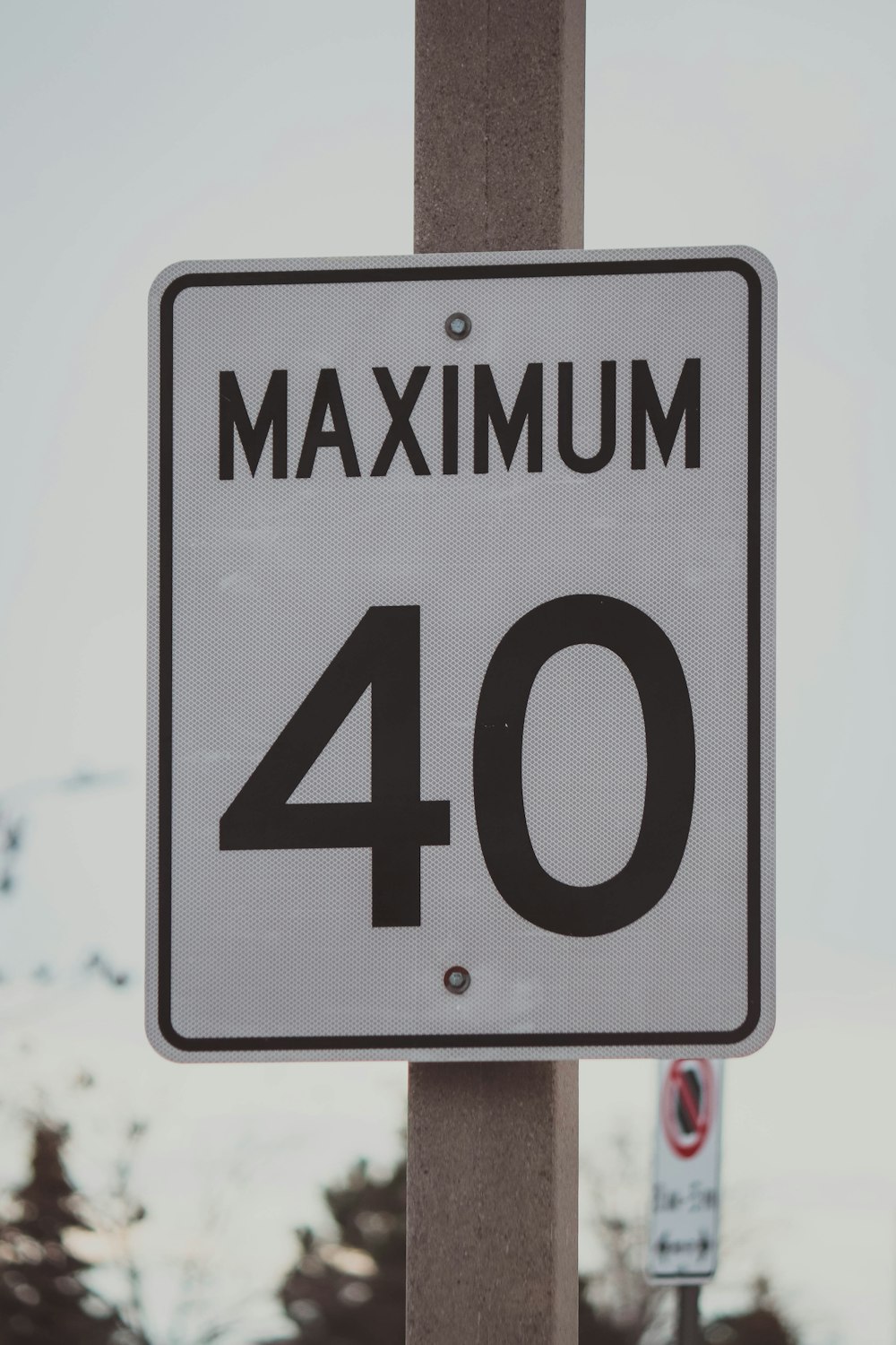 a close up of a street sign with trees in the background