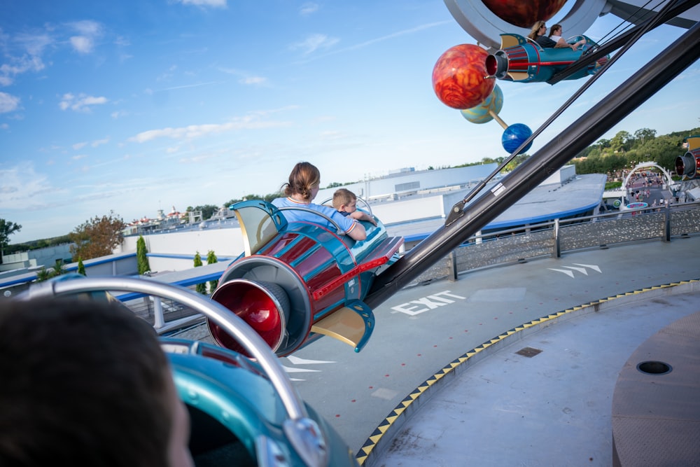 a couple of kids riding on top of a roller coaster