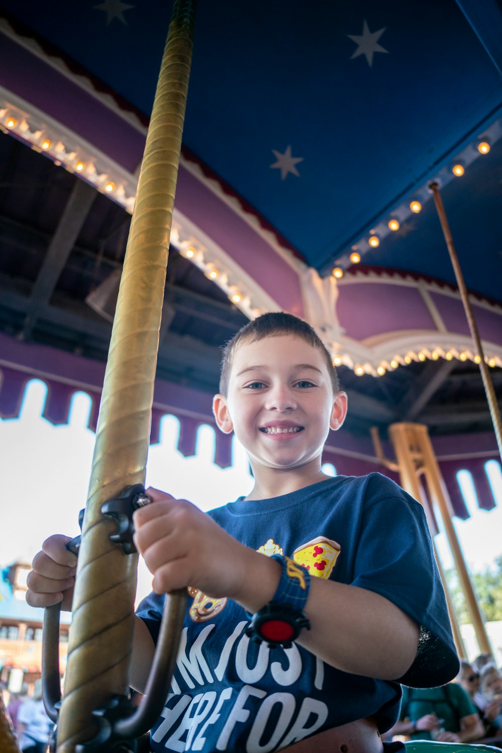 a young boy holding onto a wooden pole