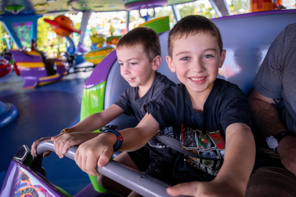 two young boys riding on a ride at a carnival