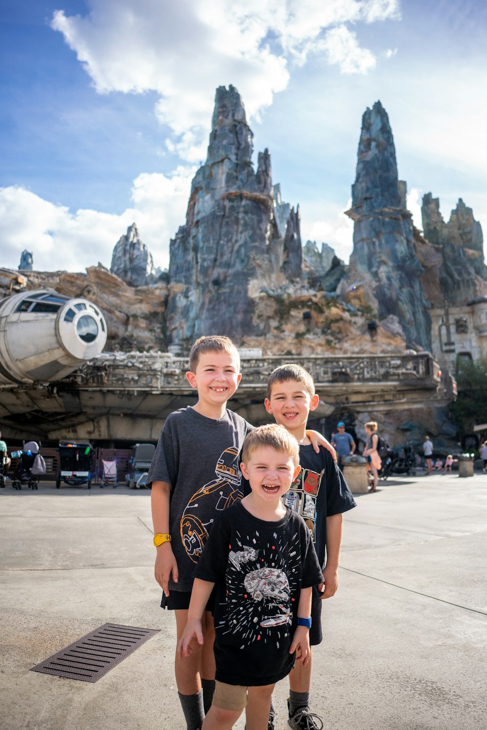 three young boys pose for a picture in front of star wars galaxy
