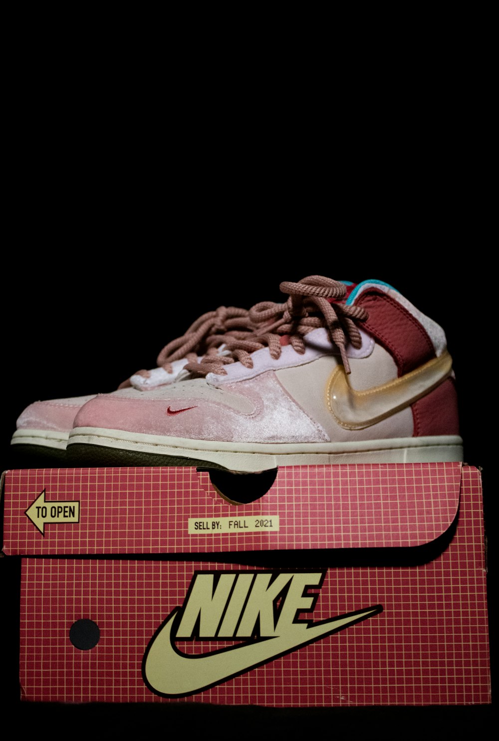 a pair of pink sneakers sitting on top of a box