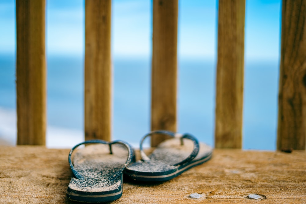 a pair of sandals sitting on top of a wooden deck