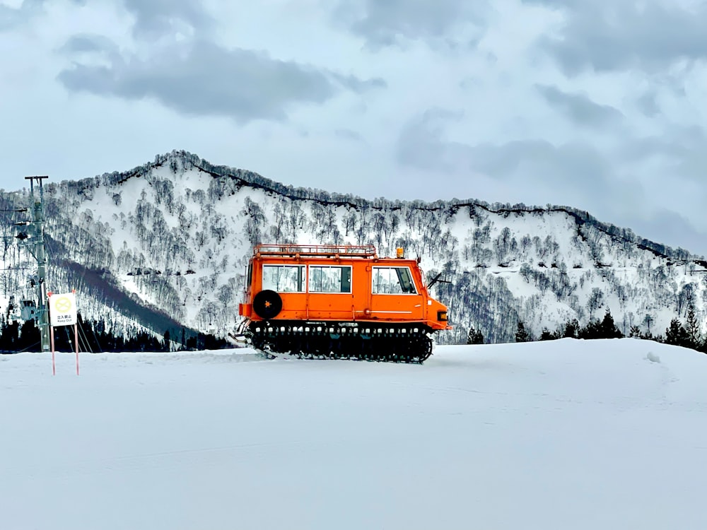 a snow plow moving across a snow covered field