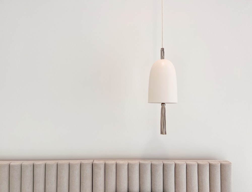 a white lamp hanging from a white wall next to a radiator