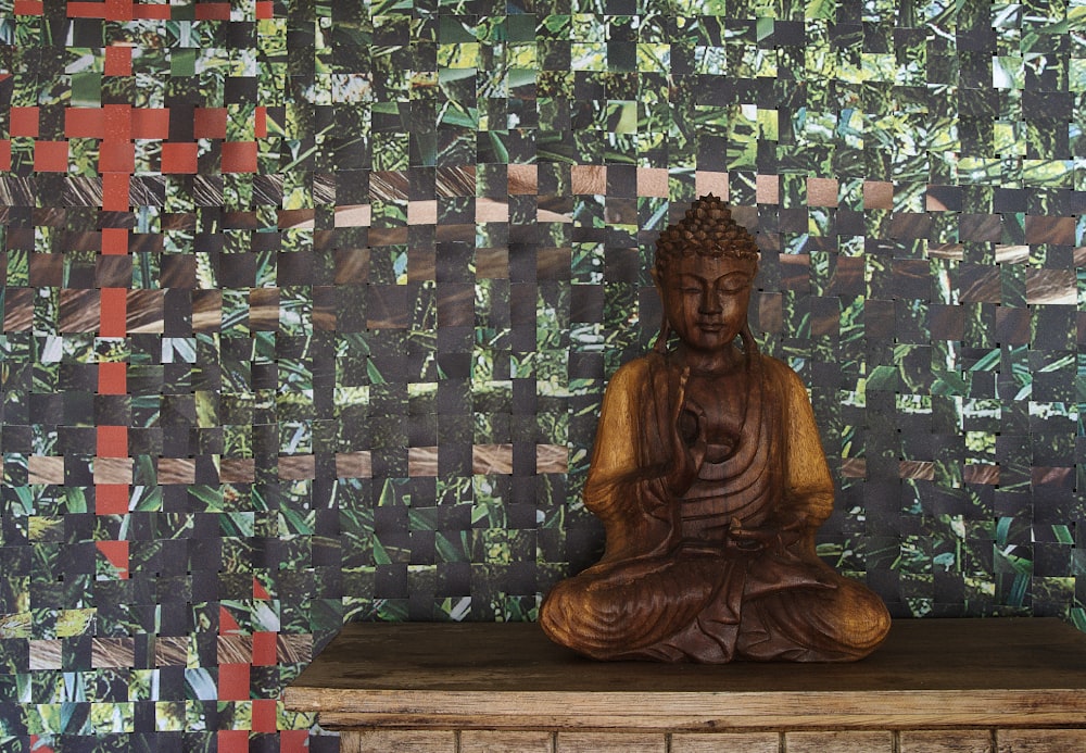 a buddha statue sitting on top of a wooden table