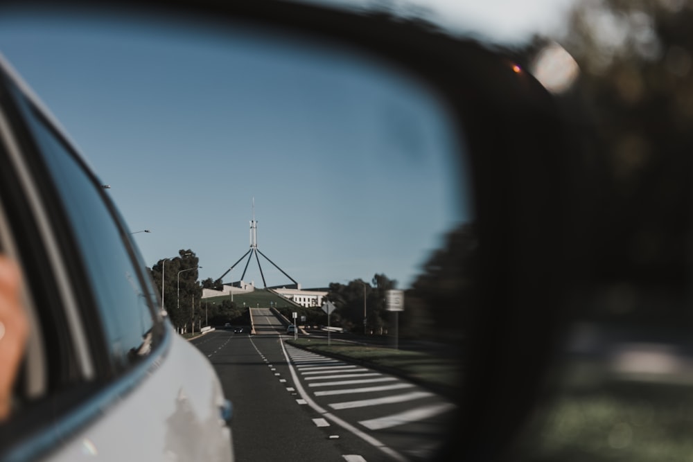 a woman's reflection in the side view mirror of a car