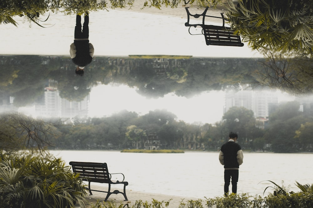 a man standing in front of a park bench