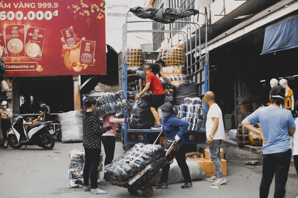 a group of people standing around a pile of luggage