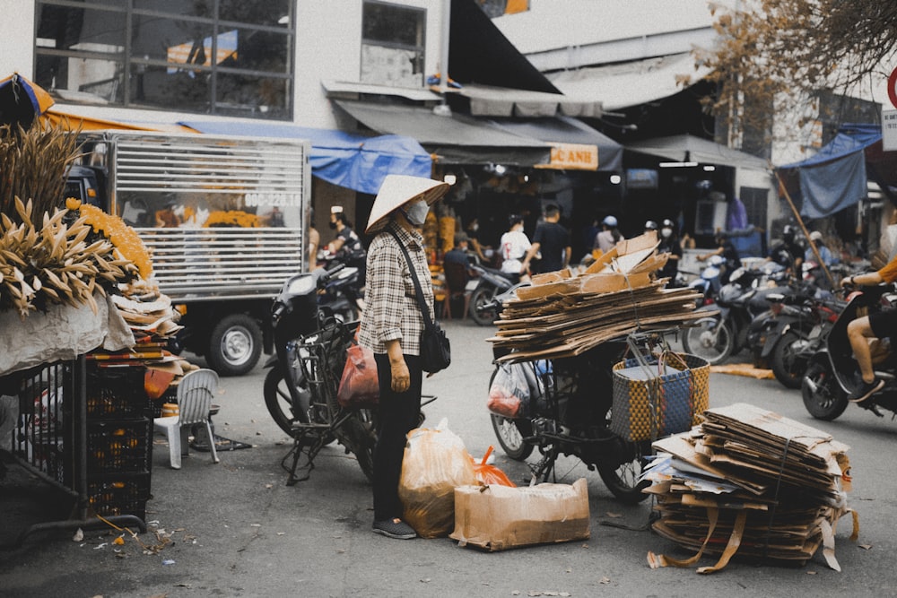 a man standing next to a pile of boxes on a street