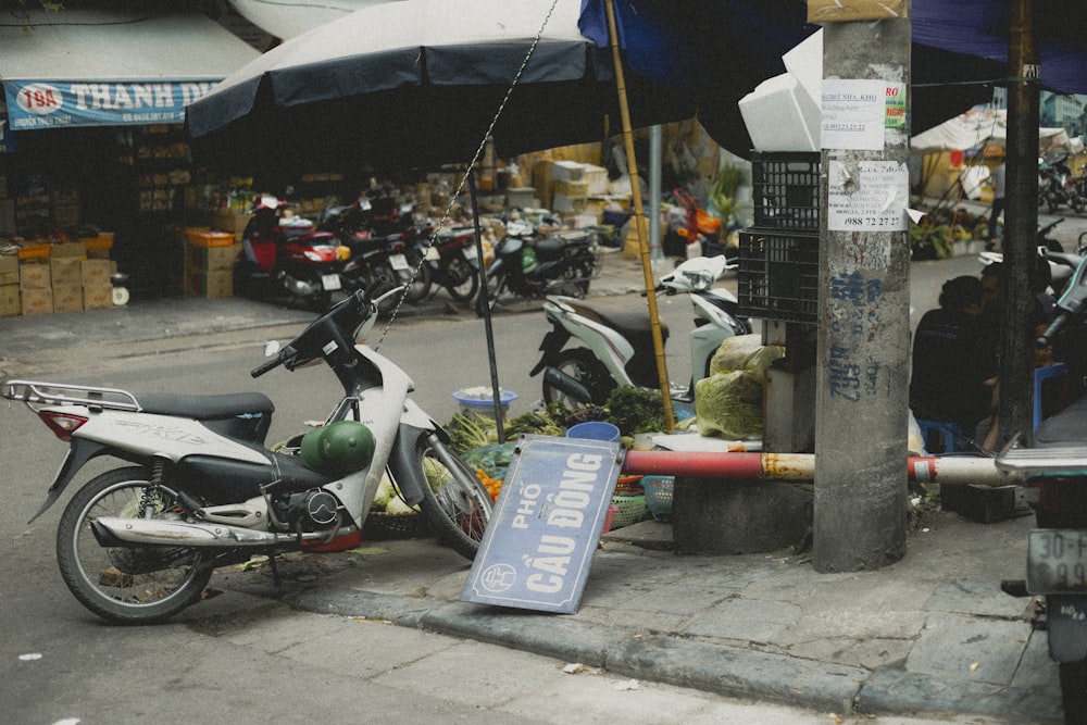 a motorcycle parked on the side of a road next to a street sign