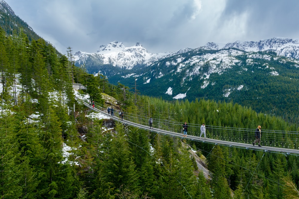 a group of people walking across a suspension bridge