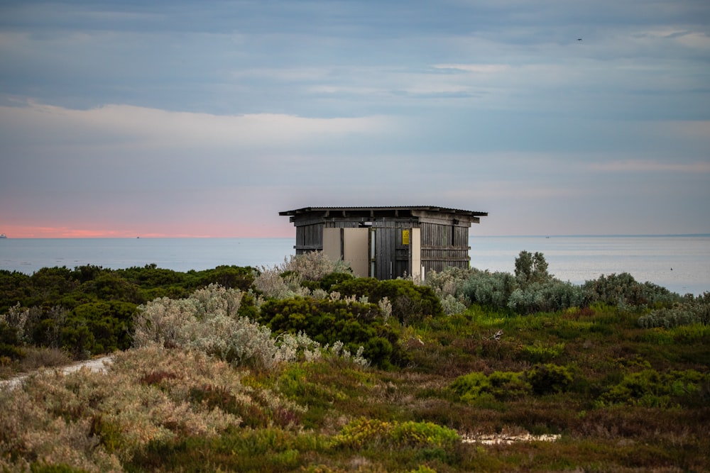 a small building sitting on top of a lush green field