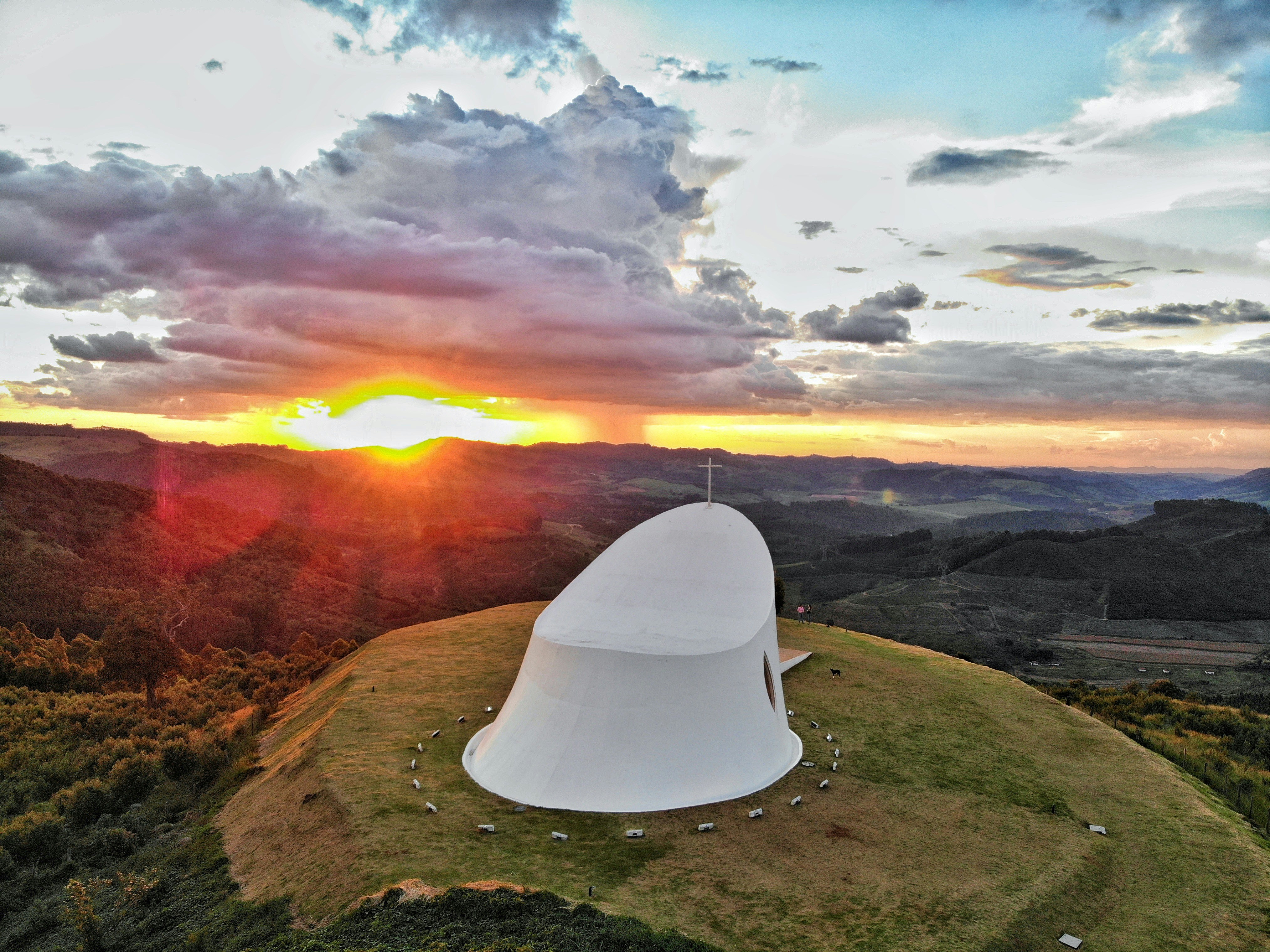 a large white structure sitting on top of a lush green hillside