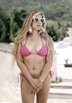 a woman in a pink bikini and sunglasses