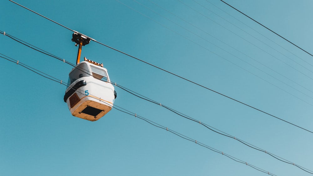 a gondola suspended from a wire in the sky