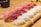 An assortment of sushi neatly arranged on a wooden serving board, featuring pieces with different types of fish such as tuna and white fish atop small mounds of rice. The setting suggests a clean, well-prepared presentation typical of Japanese cuisine.