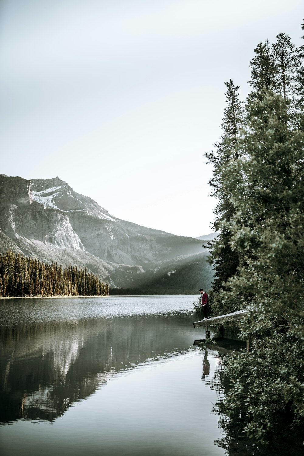 a person sitting on a boat in the middle of a lake