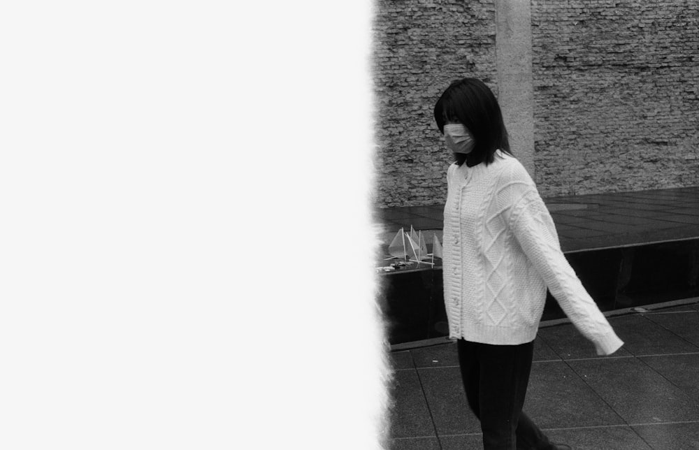 a black and white photo of a woman walking