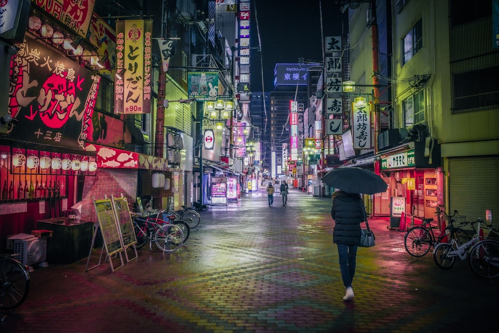 a woman walking down a street holding an umbrella