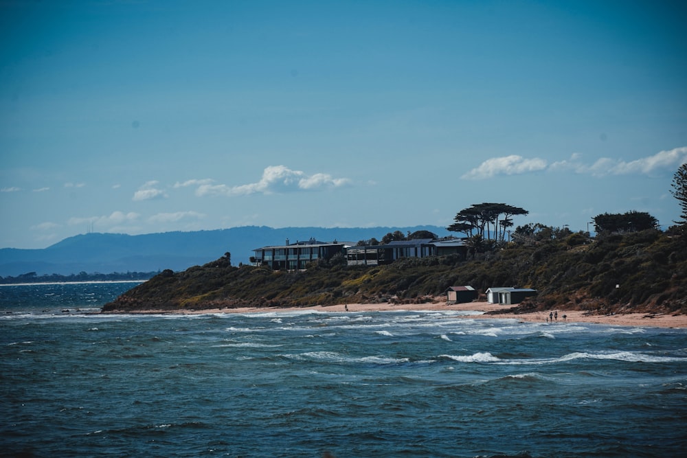 a view of a beach with houses on a hill in the background