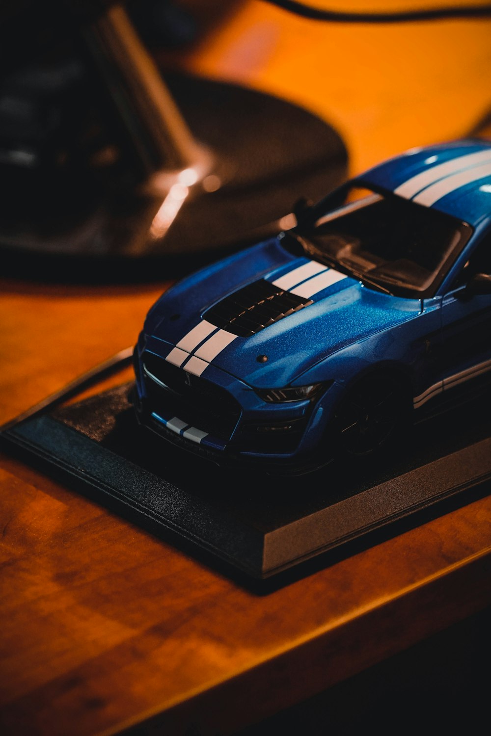 Un coche de juguete azul sentado encima de una mesa de madera