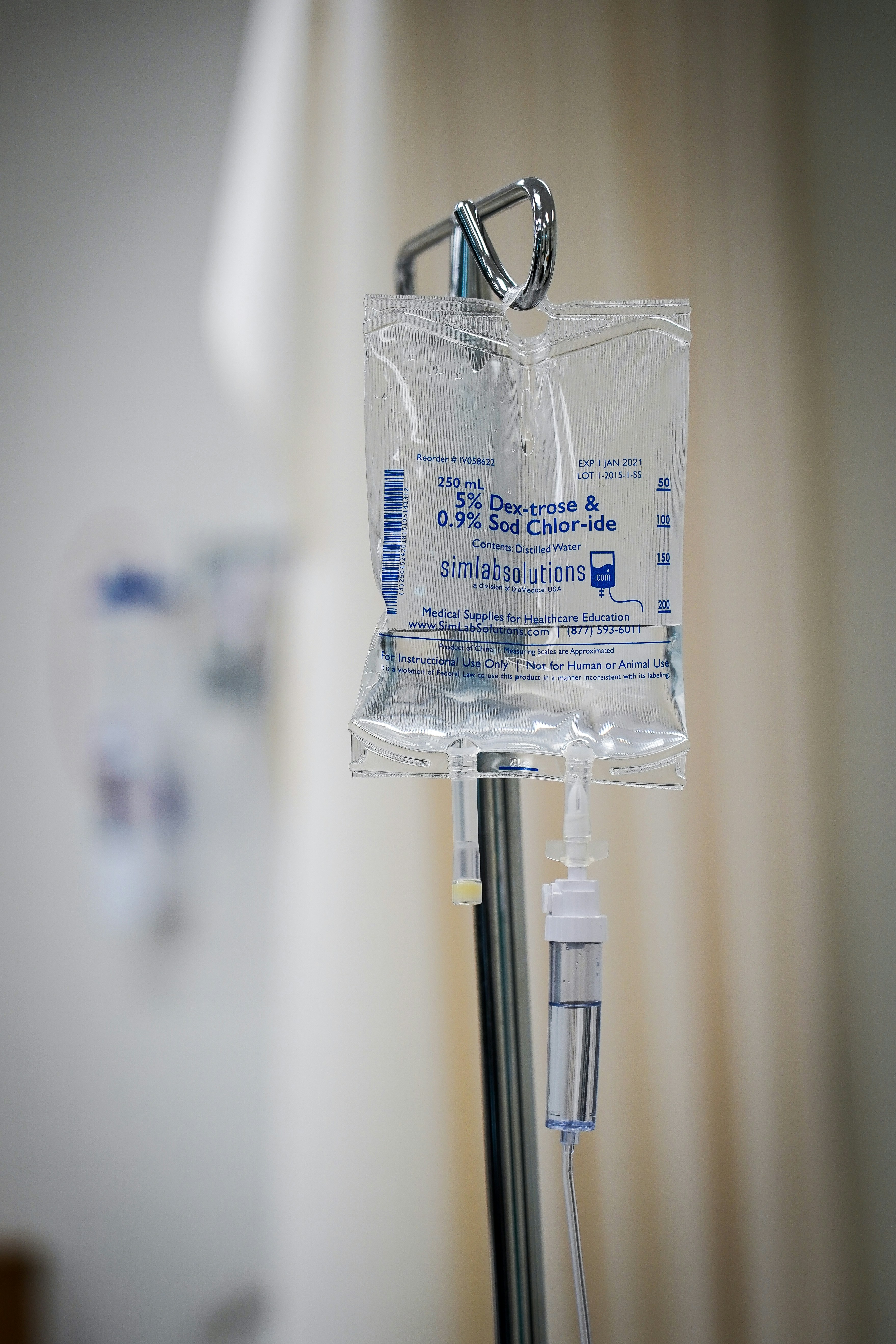 A close-up of an IV drip bag in a clinical setting.