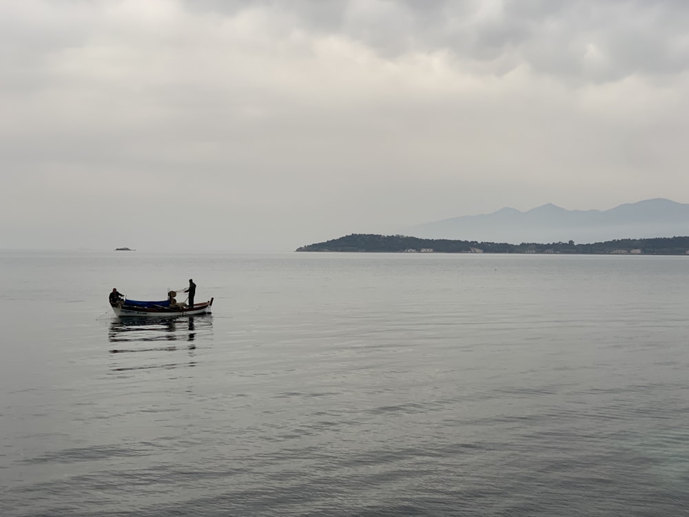 a couple of people in a small boat on a large body of water