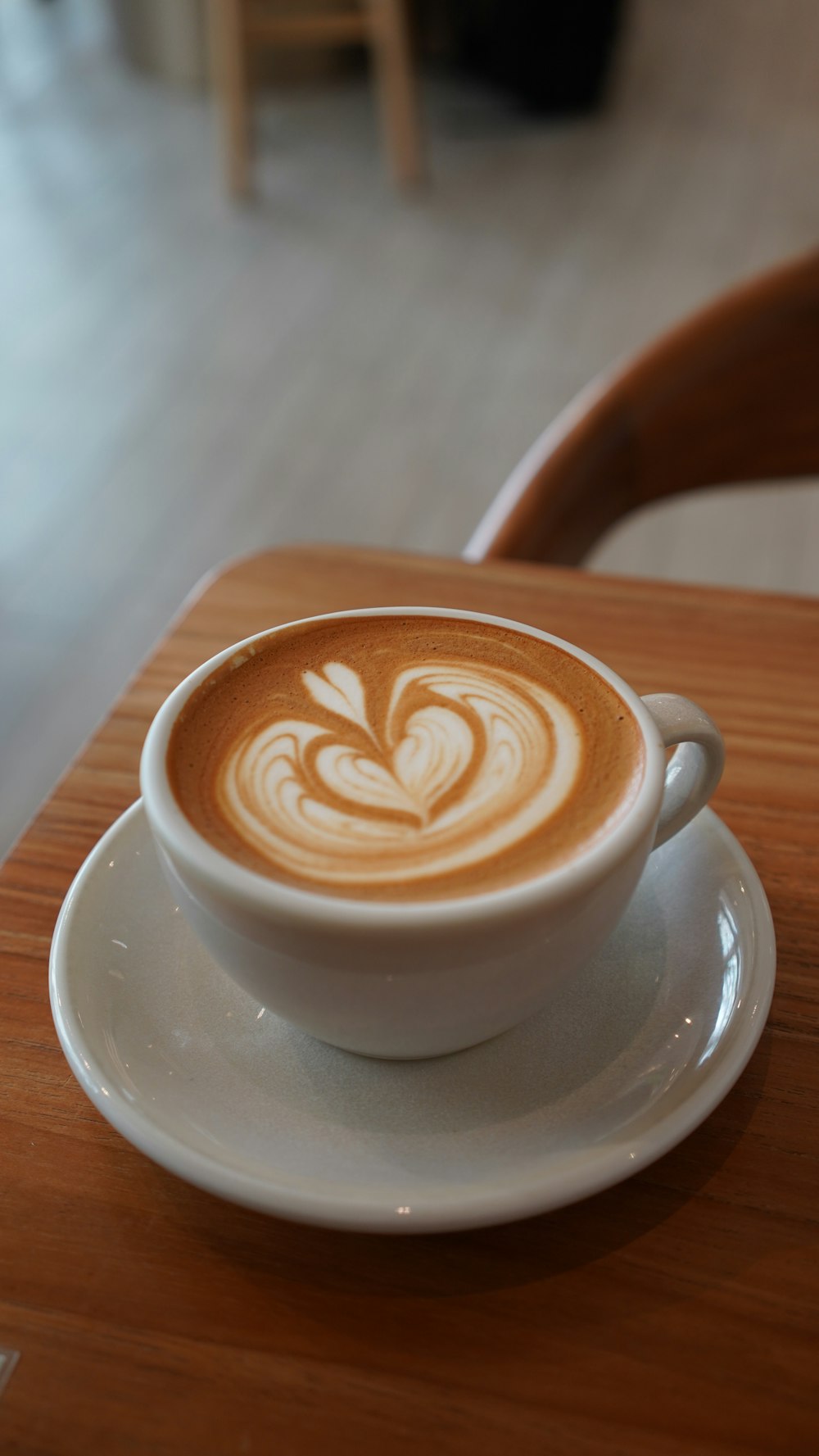 um cappuccino em um pires em uma mesa de madeira