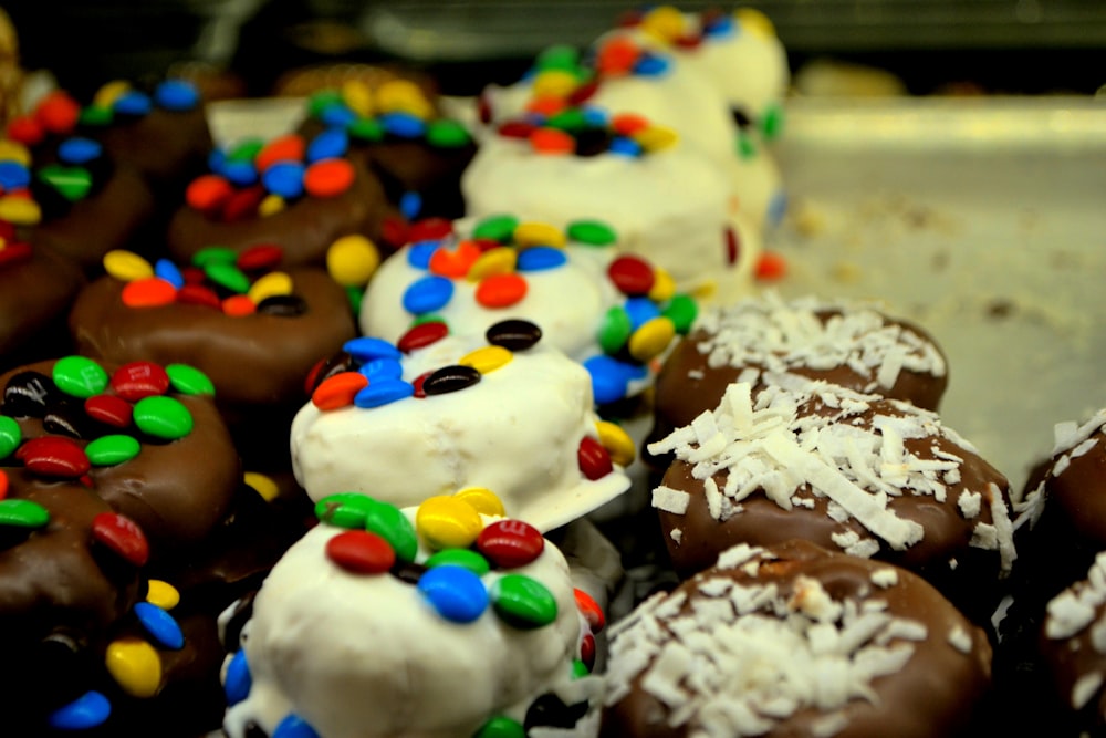 a close up of a tray of donuts with frosting and sprinkle