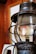 A rustic, metal lantern with a glass enclosure bears the words 'Safety First' etched on its surface. It is set against a wooden background, suggesting an antique or vintage environment.