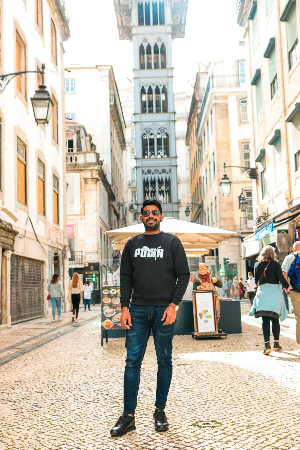 a man standing in the middle of a cobblestone street