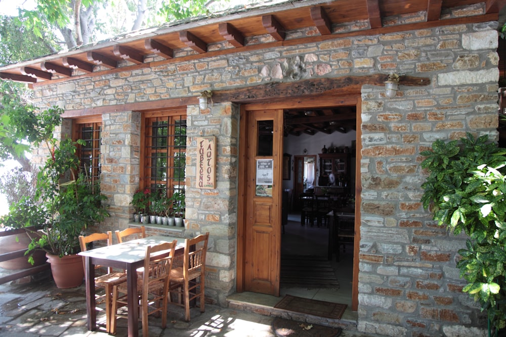 a table and chairs outside of a stone building