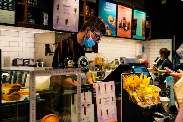a man wearing a face mask behind a counter
